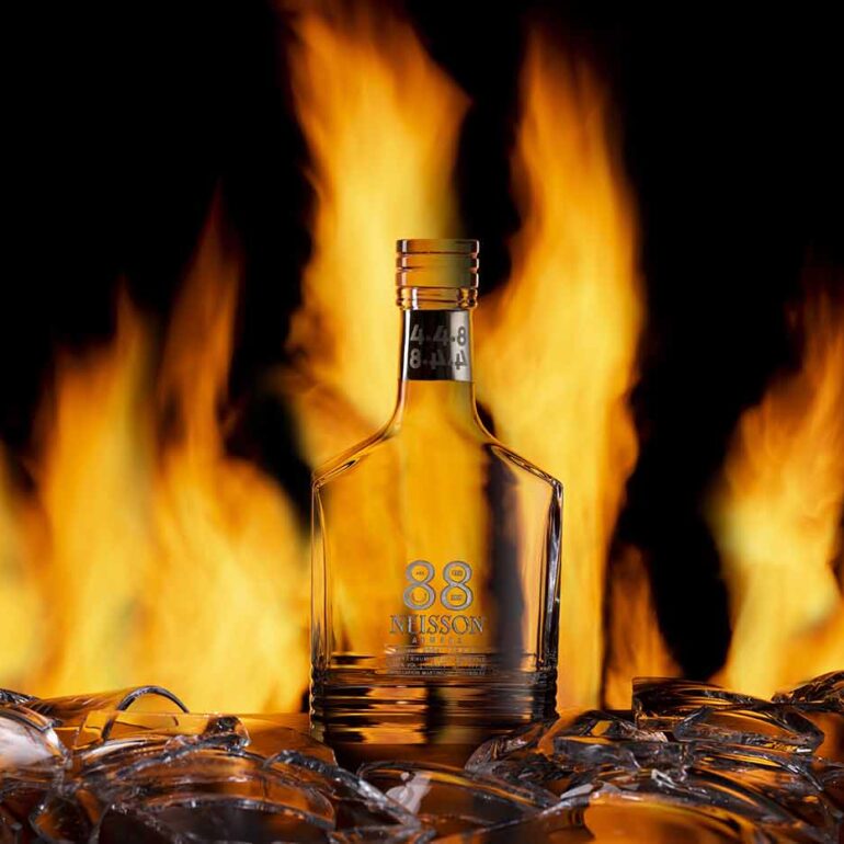 Steklenica za viski iz Steklarne Rogaška z ognjem v ozadju, produktna fotografija posneta v studiu